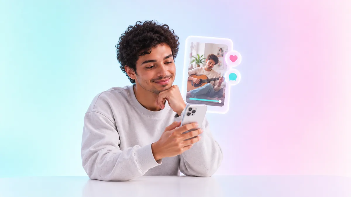 Un hombre mira su celular con una sonrisa junto a un video vertical flotante de una persona tocando guitarra, con la barra de reproducción casi completa y los íconos de me gusta y comentario
